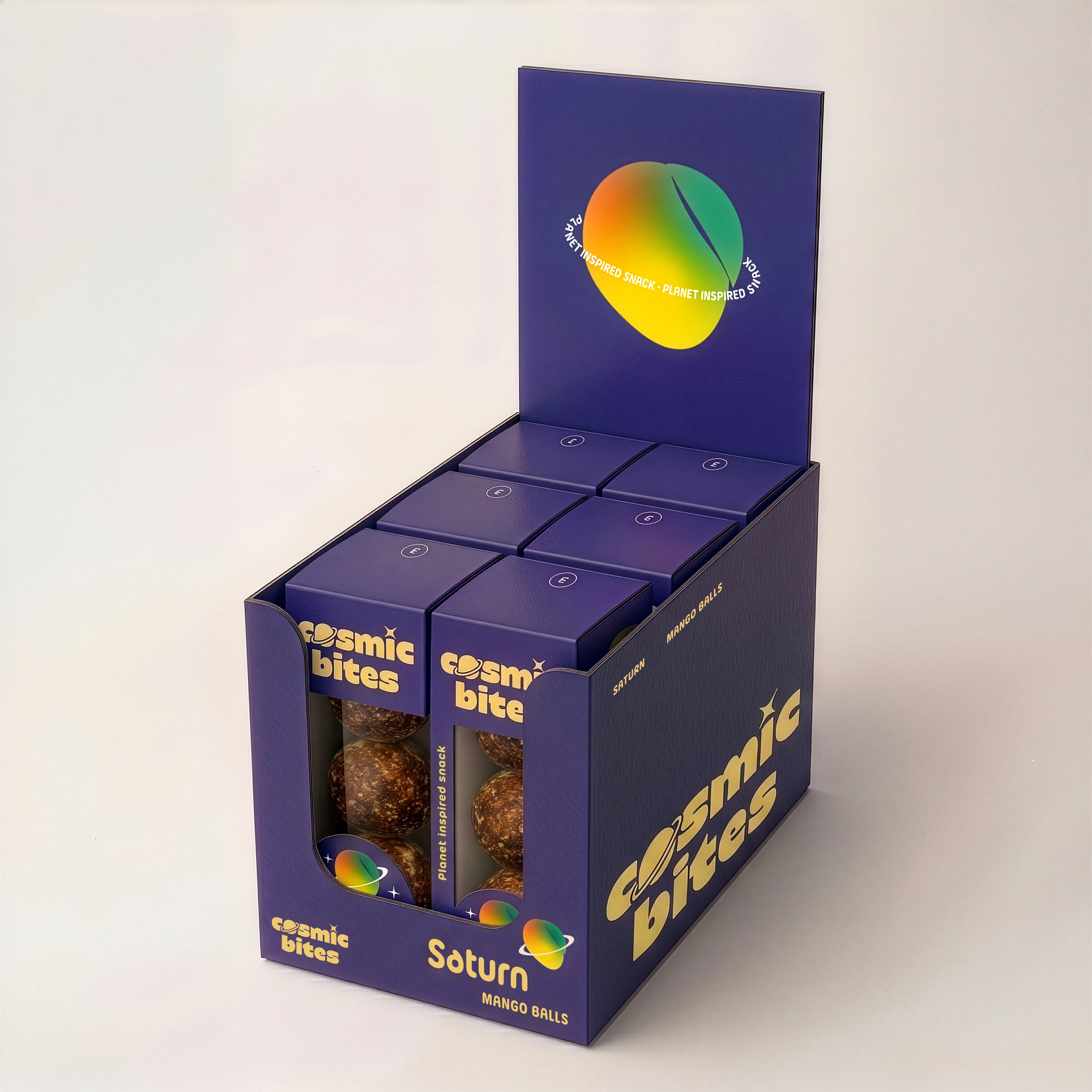 Ein Tray Cosmic Bites Energy Balls der Sorte Mango ist zu sehen, das sechs einzelne Packungen enthält. Die gelben Bälle sind dem Planeten Saturn nachempfunden, wonach die Sorte benannt ist. Der gesunde Snack besteht aus rein natürlichen Zutaten, ist vegan, hat keinen zugesetzten Zucker und einen stark reduzierten Dattelanteil von nur 25%.